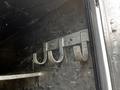 A set of three metal hooks mounted on a black surface