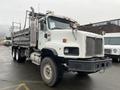 A 2003 International 5600i dump truck with a white exterior and grey cargo bed. The truck has large tires and a distinctive front grille design.