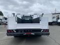 A white 2003 Ford F-450 SD pickup truck with a flatbed and trailer hitch visible at the rear with lights on the sides