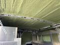 Interior of a 2023 Ford Transit van with insulated ceiling and metal shelving units on both sides