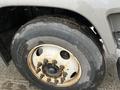 Close-up of a 2006 GMC F7B042 truck tire highlighting its tread pattern and rusted wheel rim with visible lug nuts