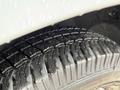 Close-up of a tire on a 2019 Mercedes-Benz Sprinter showcasing a deep tread pattern and wet surface reflecting light