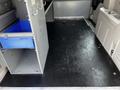 Interior view of a 2011 Dodge Grand Caravan showcasing a spacious floor with grey and black surfaces and empty storage compartments on the sides