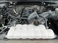 A 2017 Ford F-150 engine compartment showcasing various components including the air intake manifold and a coolant reservoir