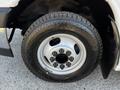 Close-up of a silver wheel with a shiny rim and black tire featuring deep treads mounted on a 2017 Chevrolet Express van