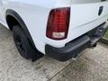 A white 2021 RAM 1500 truck showing the rear end with black accents and a textured bumper