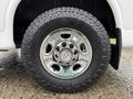 Close-up of a chrome wheel on a 2021 Chevrolet Express featuring a black tire with rugged tread design and a visible Chevrolet logo in the center of the hubcap