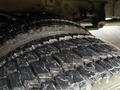 Close-up of a large tire with deep treads mounted on a 2011 Ford F-550