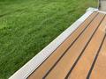 A close-up view of a wooden boat deck with the word Sylvan engraved on a metal strip