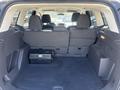 The rear interior of a 2014 Ford Escape showing a spacious cargo area with a black floor and back seats folded down