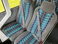 Interior seating of a 2022 Blue Bird BB Conventional featuring fabric in shades of gray and blue with seatbelts attached