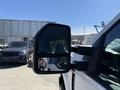 A 2017 Ford F-350 SD side mirror showing a reflection of the driver and nearby vehicles