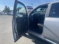 A 2021 RAM 1500 with the driver's door open showcasing the interior including the seat and dashboard