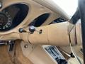 The interior view of a 1970 Chevrolet Corvette featuring a beige steering column and dashboard with a speedometer and gear shift levers