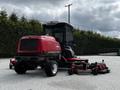 A red 2012 Toro Groundsmaster lawn mower with a covered cabin and a wide mowing deck attached to the rear