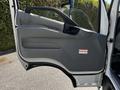A partially open driver's side door of a 2020 Hino 155 showing the interior handle panel and warning labels