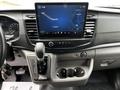 Interior dashboard of a 2022 Ford Transit featuring a touchscreen display showing navigation and audio controls alongside gear shift and cup holders