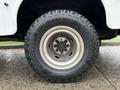 A close-up of a rugged tire mounted on a silver wheel belonging to a 2013 RAM 3500 showcasing deep treads designed for off-road traction