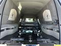 A 2013 Lincoln MKT hearse interior featuring plush seating and polished surfaces with multiple handles and fixtures designed for transporting memorial caskets