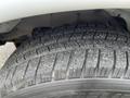 Close-up of a Michelin tire on a 2012 Chevrolet Express showing tread pattern with visible wear and dirt on the surface