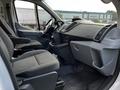 Interior view of a 2018 Ford Transit showing two front seats with fabric upholstery and a dashboard with controls and air vents
