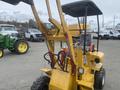 A 2024 AGT KRW 23 Mini loader with a yellow body and black wheels featuring hydraulic arms and a covered operator seat