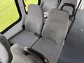 Two gray upholstered seats with armrests in a van interior, designed for passenger seating, showcasing a simple and functional design