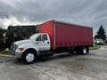 A 2008 Ford F-750 truck with a white cab and red box trailer parked with its side facing the viewer