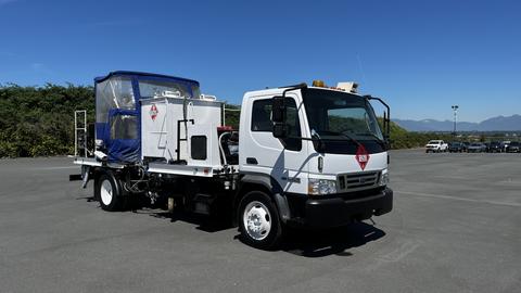 A white 2006 Ford LCF 550 truck equipped with a blue top cover and various equipment mounted in the bed