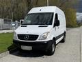 A 2012 Mercedes-Benz Sprinter van with a white exterior and black accents parked on a street