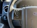 Close-up of the steering wheel of a 2014 Ford F-550 featuring control buttons for settings information and reset