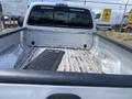 A 2007 Ford F-350 SD truck bed with visible rust and wear, featuring a rubber bed mat and a pristine cab area with a rear window showing tinted glass