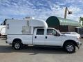 A white 2014 Ford F-350 SD with a custom box truck attachment on the back, featuring a side door and a streamlined top