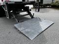 A metal loading ramp attached to a 2020 Hino 338 truck is extended and ready for use