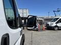 A 2016 RAM Promaster van is positioned in an industrial setting with its side mirror prominently displayed in the foreground