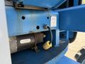 Close-up view of a 2012 Genie Z 45/25 with visible motor and electrical components showing signs of wear and rust