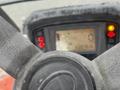 Close-up of a Kubota F3990 tractor steering wheel with a digital display showing operational indicators and warning lights