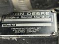 A metal identification plate with the text "JOHN DEERE Engine Serial Number XCH3009D224495 Model 31NV70-DJGM MANUFACTURED BY YANMAR CO LTD OSAKA JAPAN"