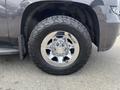 A close-up of a chrome wheel from a 2016 Chevrolet Tahoe featuring a rugged tire and the Chevrolet bowtie logo on the center cap