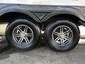 Two large tires with silver rims mounted on a trailer axle showcasing a 2022 Heartland Torque