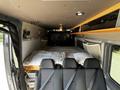 Interior of a 2017 Mercedes-Benz Sprinter with a bed setup in the back and storage shelves above