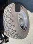 A tire from a 2018 Kubota RTV-X 1100 C with a rugged tread design and metallic rim visible in the foreground