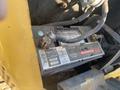 A battery from a 2006 Komatsu PC55MR2 excavator with visible terminals and labels showing specifications and warning information
