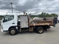 A 2008 Mitsubishi Fuso FE180 with a white cab and a flatbed body featuring metal sides and a rear tailgate in a side view