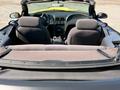 A 2003 Ford Mustang convertible interior featuring two front seats and a rear seat with a folded down backrest