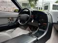 Interior of a 1992 Chevrolet Corvette featuring a black dashboard gray leather seats and a central console with various controls and a gear shifter