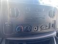 Dashboard of a 2009 Ford Econoline featuring radio controls air conditioning knobs and other electronic buttons