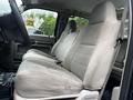 The interior of a 2008 Ford F-550 featuring two spacious front seats in light gray fabric with a textured design