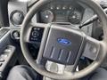 The image shows the steering wheel and dashboard of a 2015 Ford F-550 with various gauges and controls visible in the foreground