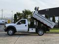 White 2006 Ford F-550 truck with a raised dump bed, showcasing a side view of the vehicle with a spacious cab and large wheels